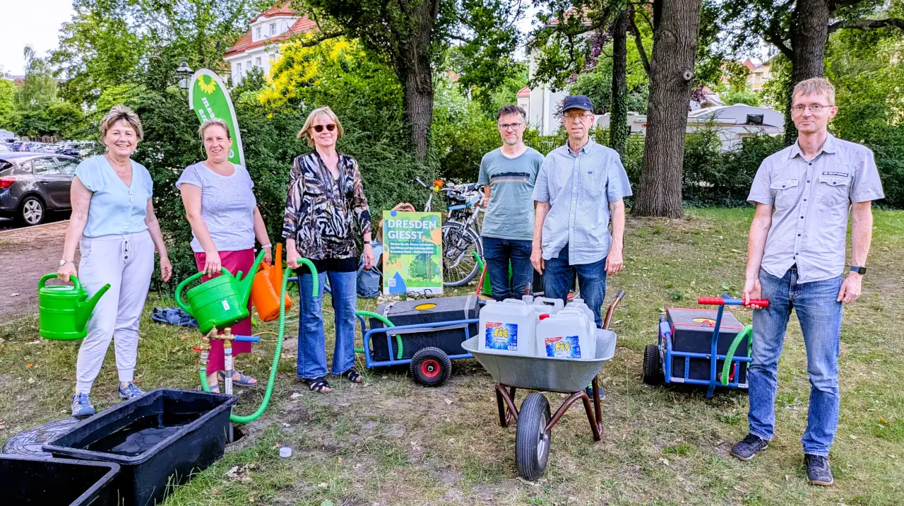 Gruppenbild Giessteam am Hydrant Stresemannplatz mit Gießwagen, Kannen und Schubkarre